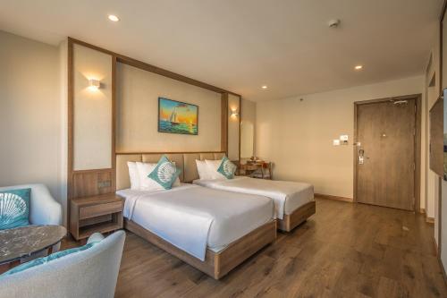 a hotel room with two beds and a chair at Sunset Beach Resort and Spa in Phu Quoc