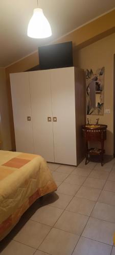 a bedroom with a bed and cabinets and a table at Dietro Piazza Maggiore in Sulmona
