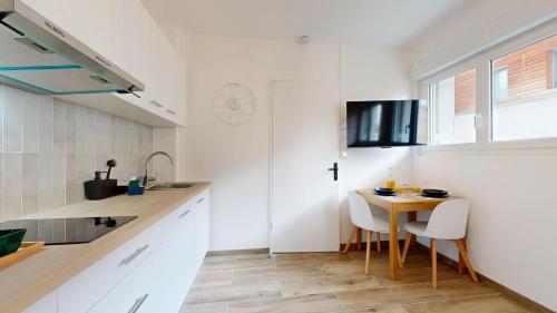 a small kitchen with a small table and chairs at expat renting - Le Dolce Vita - Netflix in Toulouse