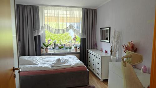 a bedroom with a bed and a window with plants at BS Business Travelling Hannover City in Hannover
