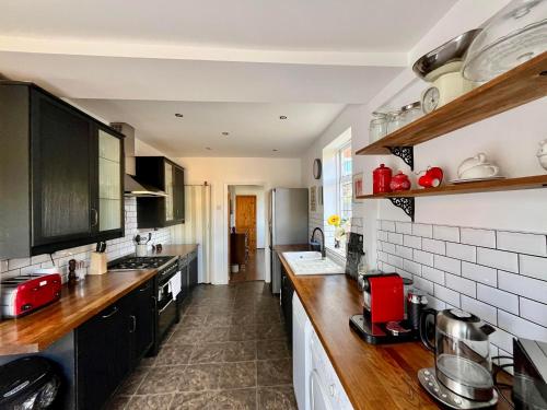 a kitchen with black cabinets and a counter top at Town House with Jacuzzi & Sauna in Nottingham
