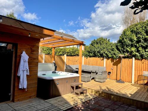 a backyard with a hot tub and a wooden deck at Town House with Jacuzzi & Sauna in Nottingham