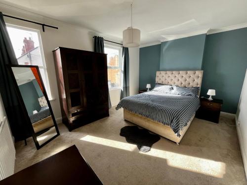 a bedroom with a bed and a mirror in it at Town House with Jacuzzi & Sauna in Nottingham