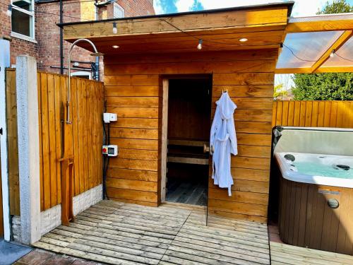 a wooden building with a bath tub and a sink at Town House with Jacuzzi & Sauna in Nottingham