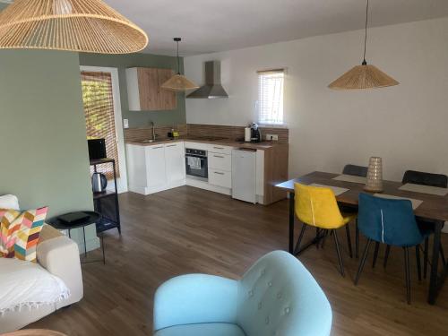 une cuisine et un salon avec une table et des chaises dans l'établissement Maison avec piscine et jacuzzi idéale pour un séjour détente, au Thor