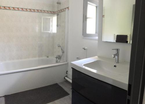 une salle de bain avec une baignoire et un lavabo et une baignoire tubermottermott dans l'établissement Mickey M'house Familly, à Magny-le-Hongre