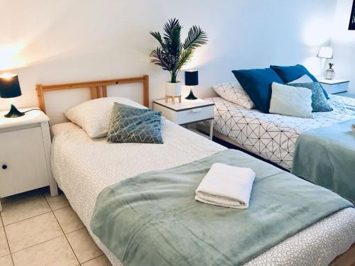 deux lits dans une chambre avec du bleu et du blanc dans l'établissement Mickey M'house Familly, à Magny-le-Hongre