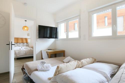 a white room with two beds and a television at expat renting - Le Dolce Vita - Netflix in Toulouse