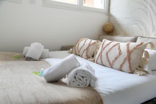 a white bed with towels and pillows on it at expat renting - Le Dolce Vita - Netflix in Toulouse