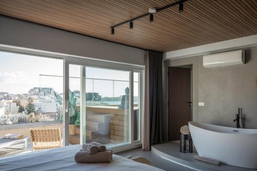 a bedroom with a bath tub and a large window at ROP Penthouse & ROF Apartment by Homega, Terrace, Private Pool & Valletta Views in Sliema