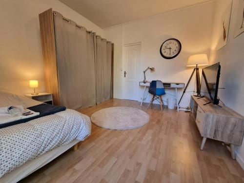 une chambre avec un lit et une horloge au mur dans l'établissement Mont d'arène superbe appartement proche gare, à Reims