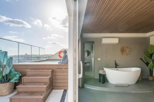 a bathroom with a bath tub and a large window at ROP Penthouse & ROF Apartment by Homega, Terrace, Private Pool & Valletta Views in Sliema