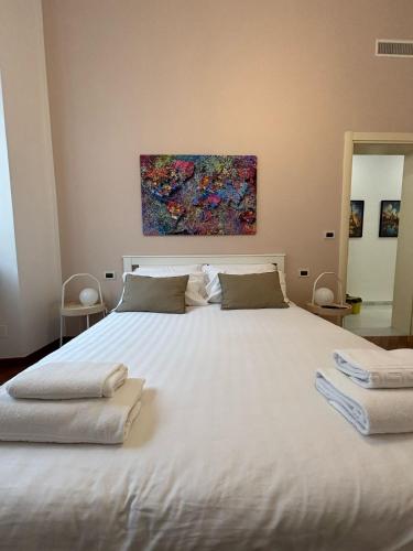 a large white bed with a painting on the wall at Miramare Serenella in Genoa