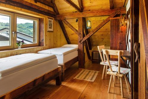 a bedroom with two beds and a desk in a cabin at Farm Stay Pirc - Hayloft Apartment in Laško