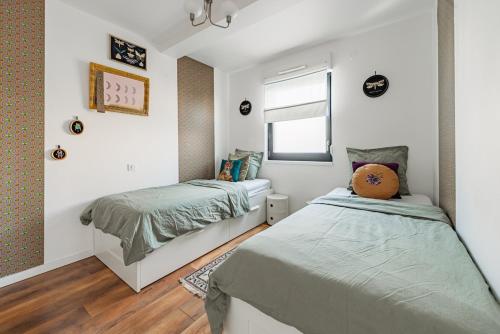 a bedroom with two beds and a window at Grand 3 pièces à 10 min de Strasbourg in Achenheim