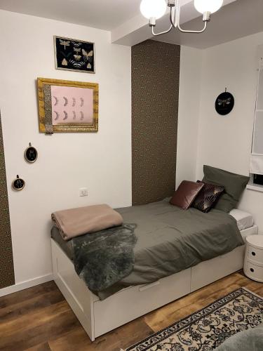 a bedroom with a bed with a green comforter at Grand 3 pièces à 10 min de Strasbourg in Achenheim