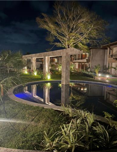 a house with a swimming pool at night at Itacimirim Bioflora in Itacimirim