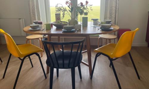 a wooden table with four chairs and a table and a table and chairs at Ollediek in Houwerzijl