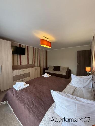 a hotel room with two beds and a couch at Apartamente Felix in Baile Felix