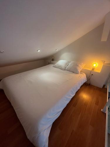 a large white bed in a room with a lamp at Romane Amneville proximité A31 Thermal Lux in Amnéville
