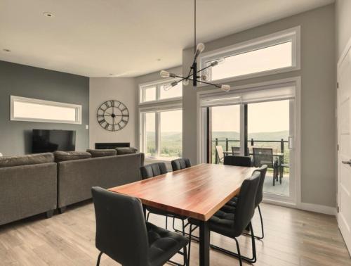 ein Esszimmer mit einem Holztisch und Stühlen in der Unterkunft Condo Matha in Saint-Jean-de-Matha
