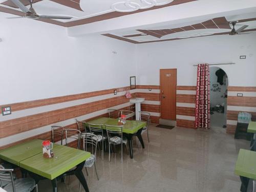 a dining room with green tables and chairs at Hotel An Himalayan View in Barkot