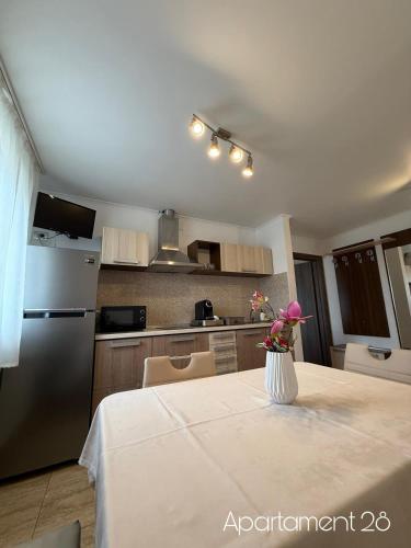 a kitchen with a table with a vase of flowers on it at Apartamente Felix in Baile Felix