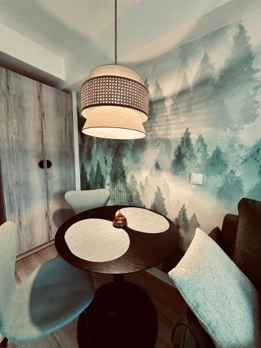 a dining room with a table and a chandelier at Apartament Zielona Równica in Ustroń