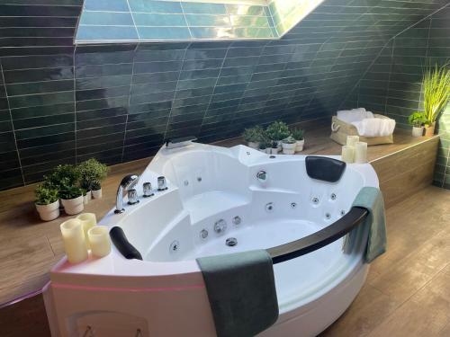 a large bath tub in a bathroom with plants at La Clé des Champs - Studio PiscineSPA-Sauna au jardin tropical idyllique et bucolique in Jouarre