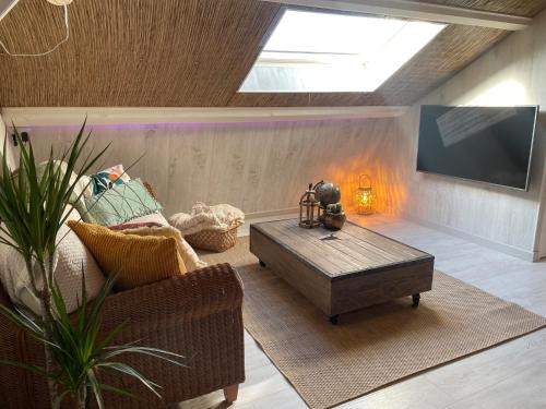a living room with a couch and a coffee table at La Clé des Champs - Studio PiscineSPA-Sauna au jardin tropical idyllique et bucolique in Jouarre