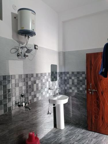 a bathroom with a sink and a fan at Hotel An Himalayan View in Barkot