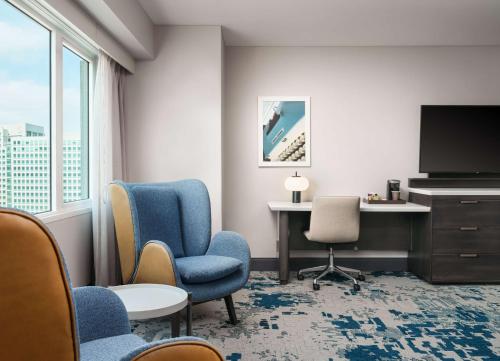 a hotel room with a desk and chairs and a tv at Hilton San Jose in San Jose