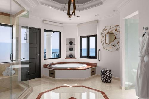 a bathroom with a tub and a glass shower at Hilton Los Cabos in San José del Cabo