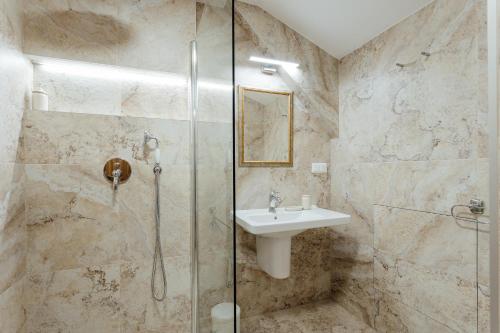 Un baño con lavabo y ducha de cristal. en Apartmány FRANZ, en Banská Štiavnica