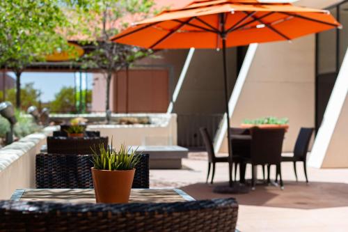 a table with an orange umbrella on a patio at Hilton Salt Lake City Center in Salt Lake City