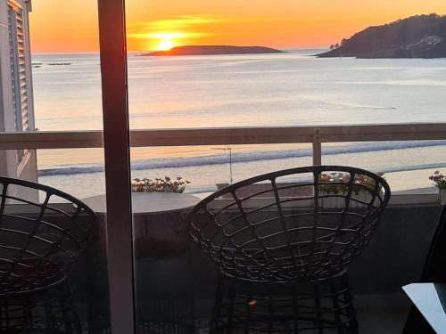 a view of the ocean from a balcony with two chairs at Panxon Madorra Mar in Panjón