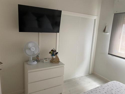 1 dormitorio con vestidor y TV en la pared en Panxon Madorra Mar, en Panjón