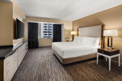 a hotel room with a bed and a television at Hilton Salt Lake City Center in Salt Lake City