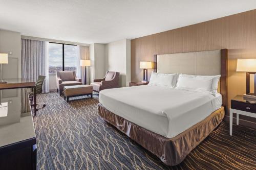 a hotel room with a large bed and a desk at Hilton Salt Lake City Center in Salt Lake City