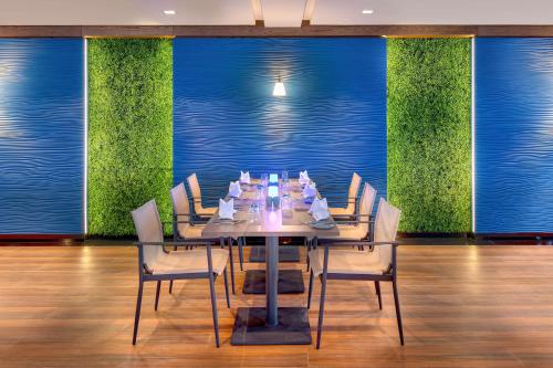 a dining room with a table and chairs and blue walls at Hilton Salalah Resort in Salalah