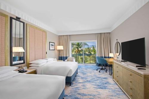 a hotel room with two beds and a flat screen tv at Hilton Salalah Resort in Salalah
