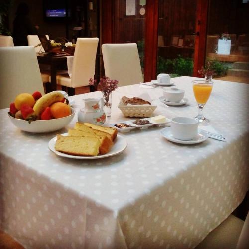 a table with a white table cloth with food on it at A Cantaruxa Maruxa Turismo Rural in Mondariz