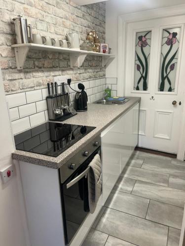 a kitchen with a stove and a counter top at Lovely 1 bed flat in Victorian house 300m seafront in Penzance
