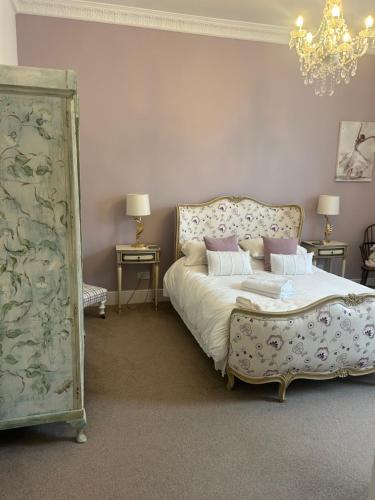 a bedroom with a bed and a chandelier at Lovely 1 bed flat in Victorian house 300m seafront in Penzance