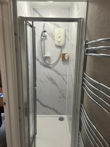 a shower with a glass door in a bathroom at Lovely 1 bed flat in Victorian house 300m seafront in Penzance