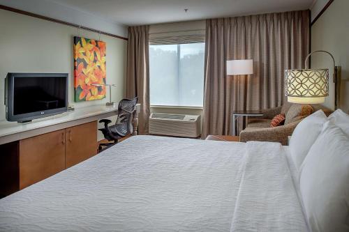 a hotel room with a bed and a television at Hilton Garden Inn St. Louis/Chesterfield in Chesterfield