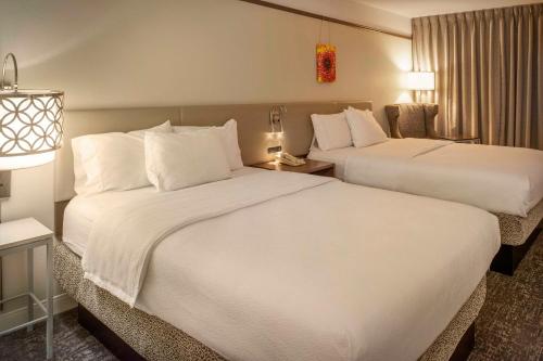 a hotel room with two beds and a desk at Hilton Garden Inn St. Louis/Chesterfield in Chesterfield