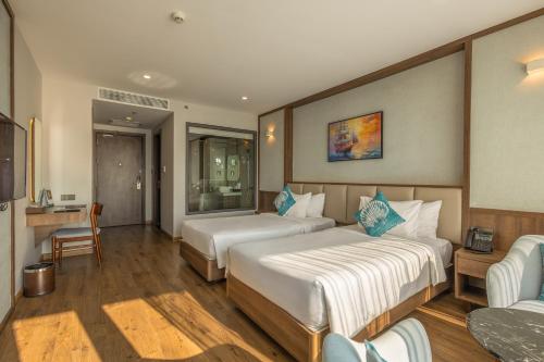 a hotel room with two beds and a couch at Sunset Beach Resort and Spa in Phu Quoc