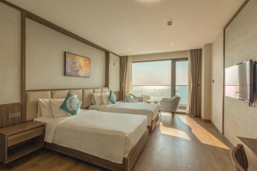 a hotel room with two beds and a television at Sunset Beach Resort and Spa in Phu Quoc