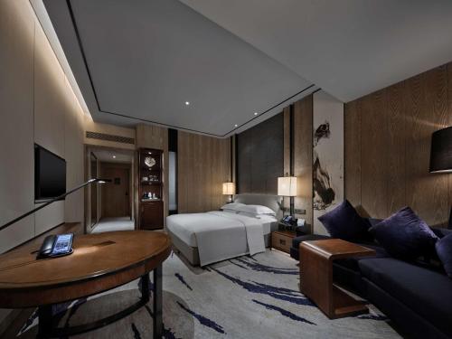 a hotel room with a bed and a couch at Hilton Shenzhen Shekou Nanhai in Shenzhen